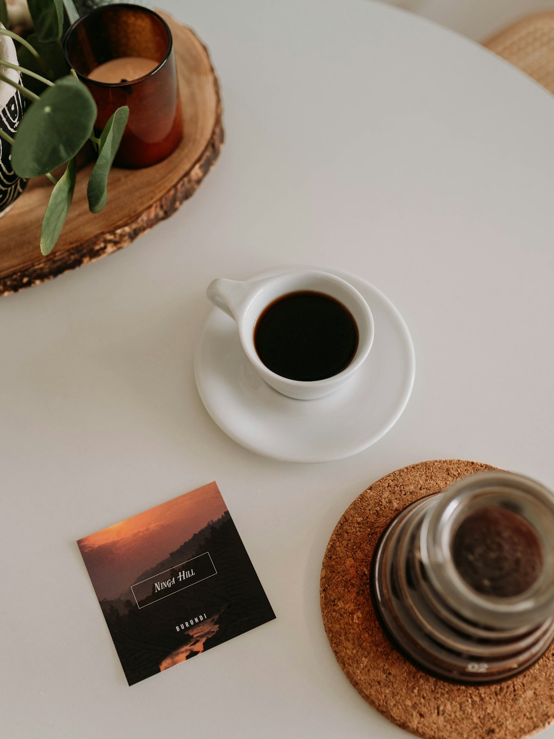 Black coffee in a cup next to a glass carafe.